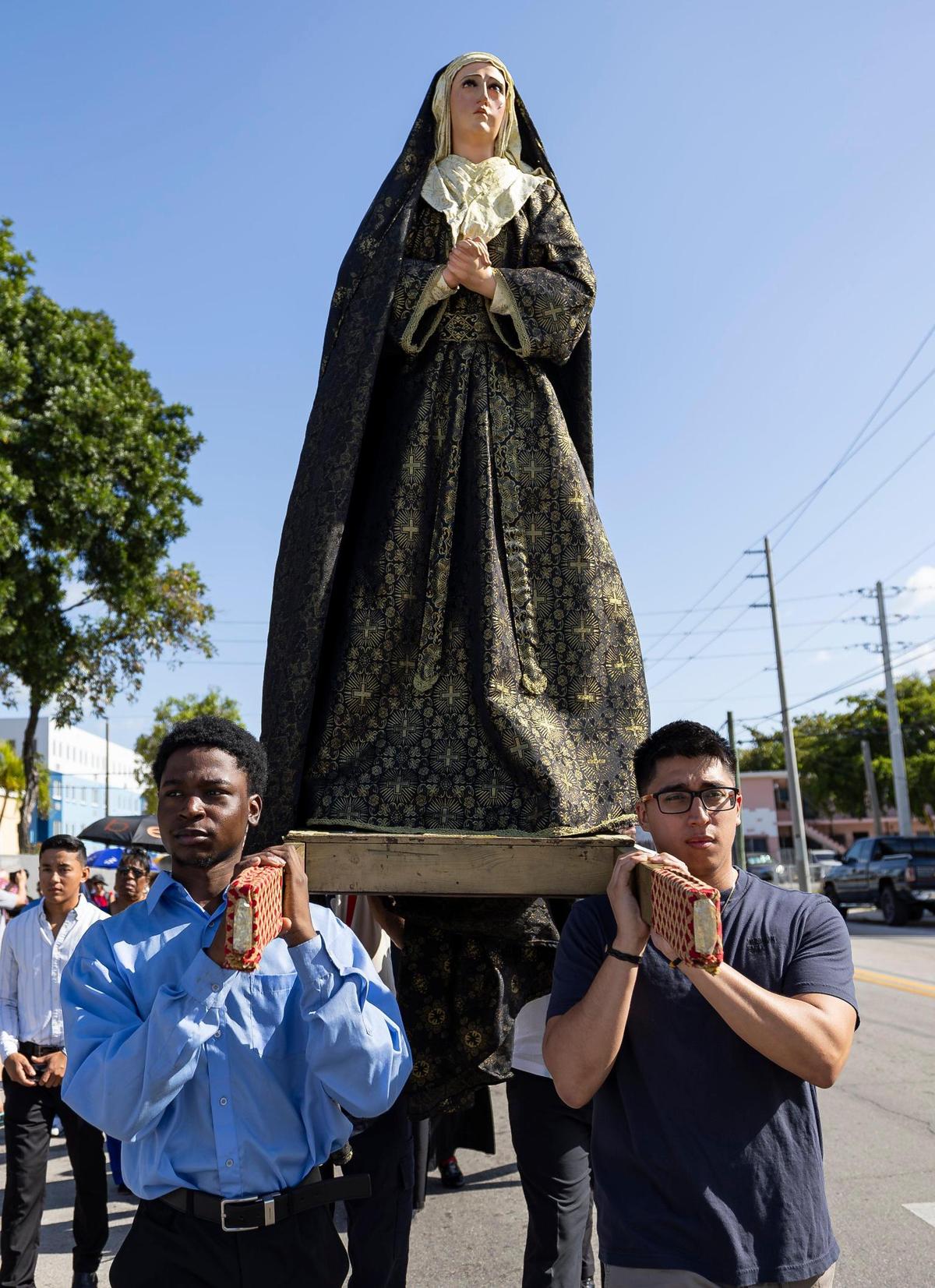 Andy Cadet, 21, left, and Kevin Perez, 29, carry a statue of Virgin Mary during a Living Stations of the Cross procession near the Cathedral of St. Mary on Friday, April 18, 2025, in Miami, Fla.