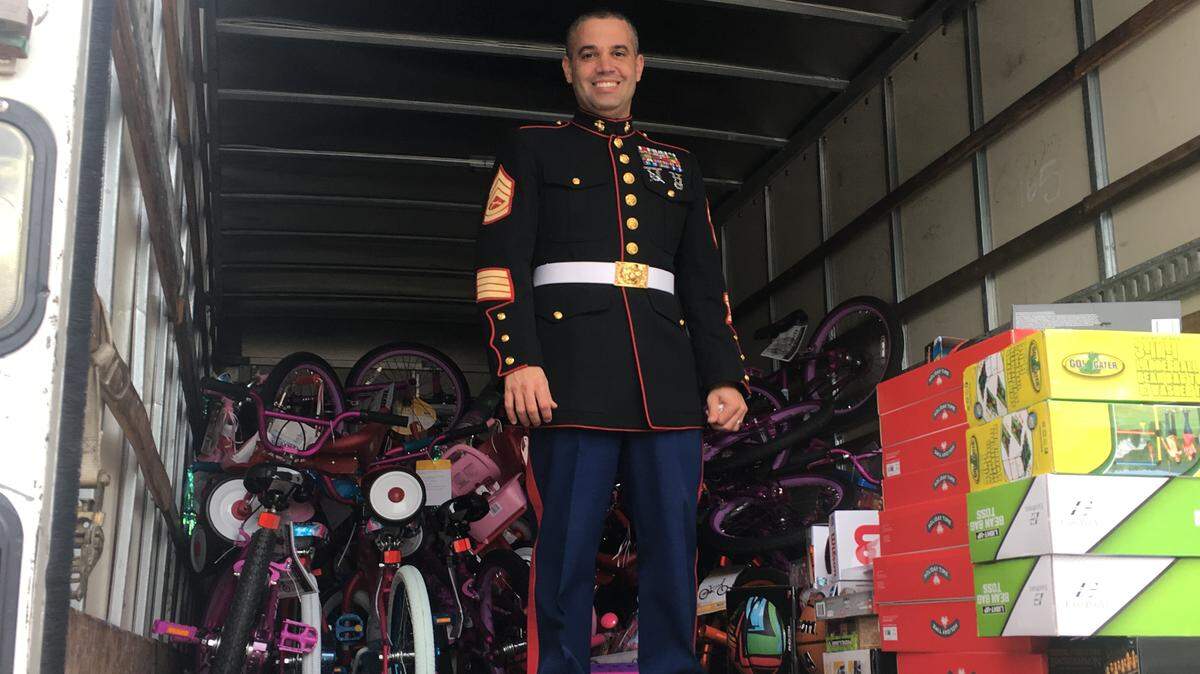 Gunnery Sgt. Dennis Polo stands in a truck Dec. 13, 2018, with toys being delivered as part of the Marine Toys for Tots program.