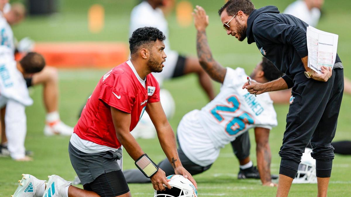 El quarterback de los Miami Dolphins, Tua Tagovailoa (1), habla con el entrenador Mike McDaniel en el Baptist Health Training Complex en Miami Gardens, Florida, el miércoles 21 de diciembre de 2022.