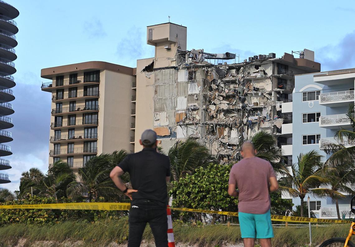 People look at the rubble at Champlain Towers South Condo in Surfside, located at 8777 Collins Avenue. Part of the building collapsed in the early morning of Thursday, June 24, 2021.
