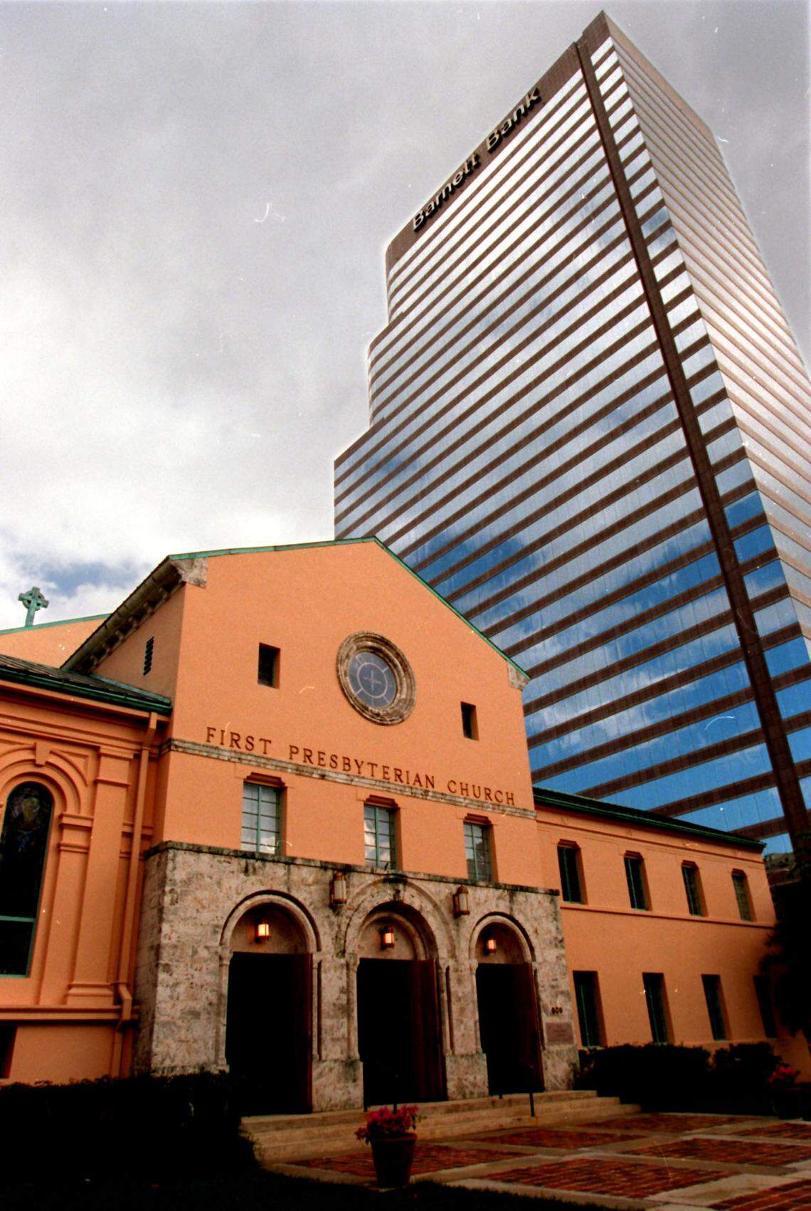 A skyscraper looms over the First Presbyterian Church of Miami in this file photo taken in 1996.