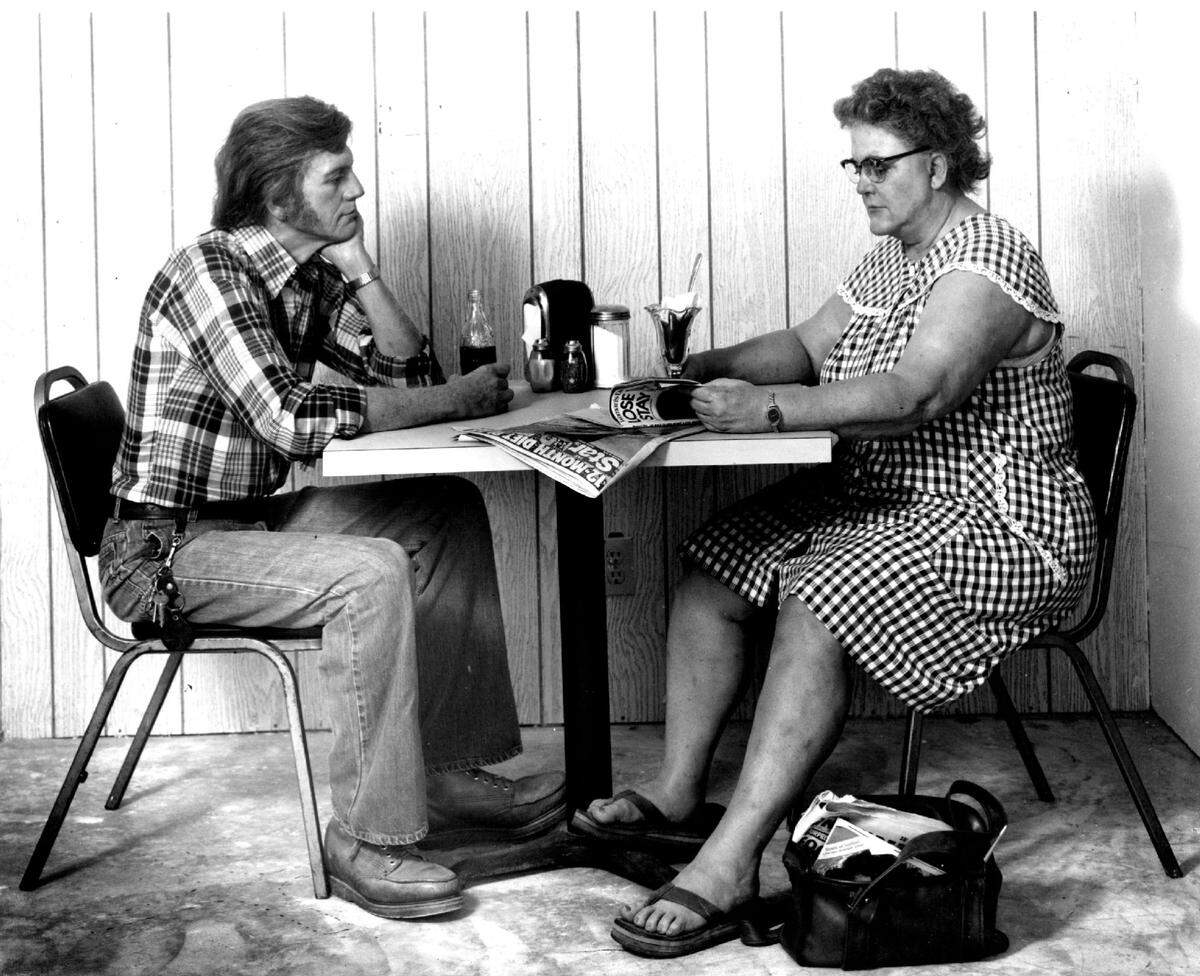 A couple at a restaurant table by Duane Hanson.