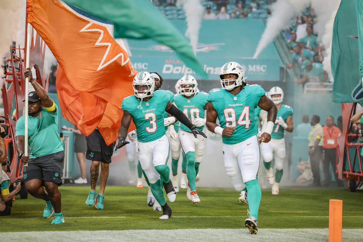 Miami Dolphins linebacker K.J. Britt (3) and defensive tackle Jordan Phillips (94) rush the field with teammates before the start of an NFL football game against the Jacksonville Jaguars at Hard Rock Stadium in Miami Gardens, Florida, on Saturday, August 23, 2025.