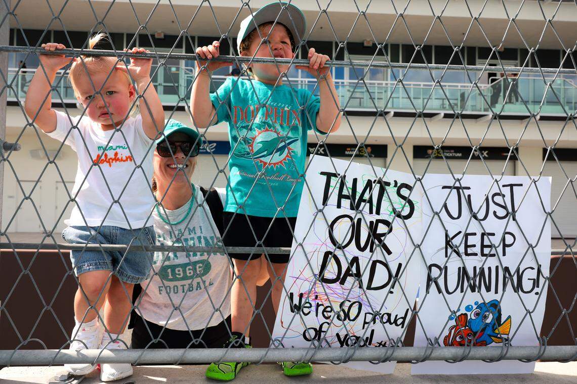 Alyssa Clark, mom of Rylee, 1, left, and Bear, 3, right, cheers for their dad, Miami Dolphins defensive line coach Austin Clark, during the Dolphins Cancer Challenge XVI event at Hard Rock Stadium in Miami Gardens, Florida, on Feb. 28, 2026.