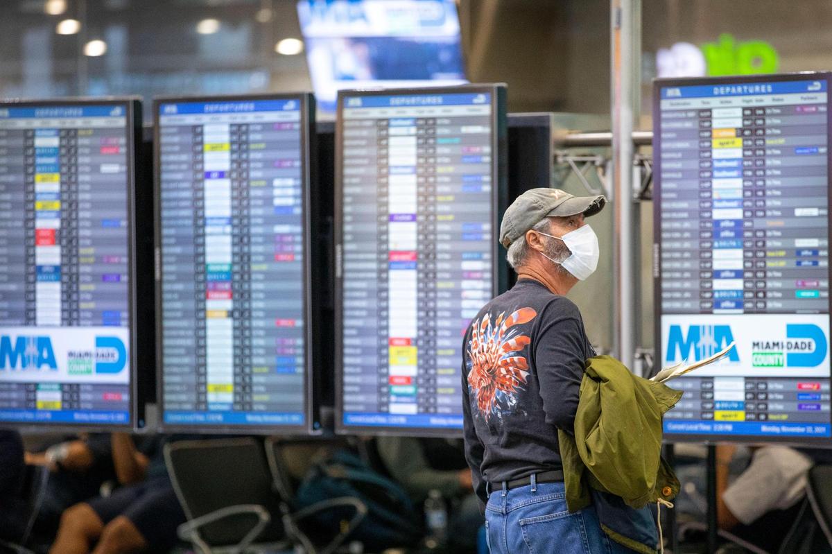 A traveler checks flight times at Miami International Airport in Miami, Florida, on Monday, November 22, 2021.