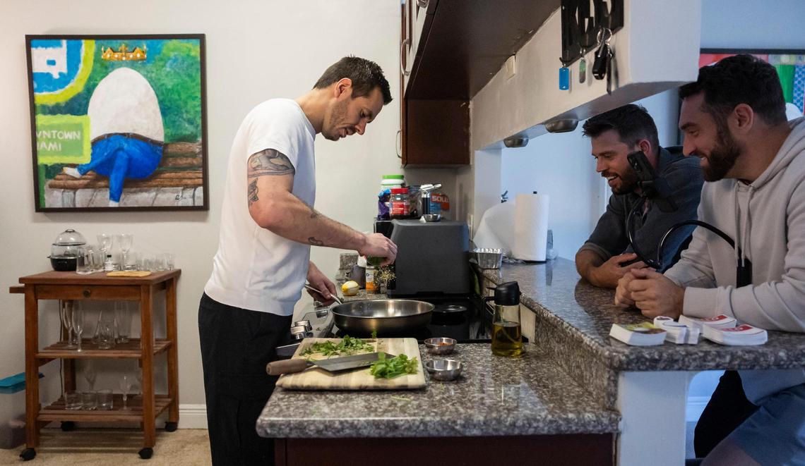 From left to right: David Zarco, 36, his roommate and their friend, Mike Cotugno, 36, in the kitchen working on a recipe he got out of a Ziploc bag of recipes from his roommate’s late, estranged uncle Greg. He started a TikTok account called “Dead Greg’s Recipes,” which gained traction after he began recreating the meals.