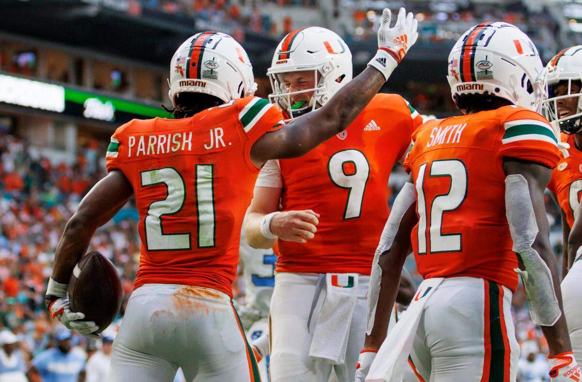 Miami Hurricanes running back Henry Parrish Jr. (21) celebrates with teammate quarterback Tyler Van Dyke (9) after scoring a touchdown during the second quarter of an ACC conference football game against North Carolina Tar Heels at Hard Rock Stadium on Saturday, October 8, 2022 in Miami Gardens, Florida..