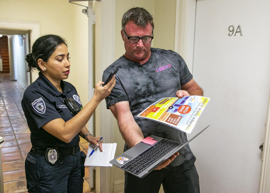 Miami Beach Code Compliance Officer Vijma Maharaj takes a photo of documents presented by Michael Simmer, a tourist staying at 1518 Drexel Avenue. Officer Maharaj was at the building inspecting for illegal short-term rentals in Miami Beach on Friday, Feb. 22, 2019.