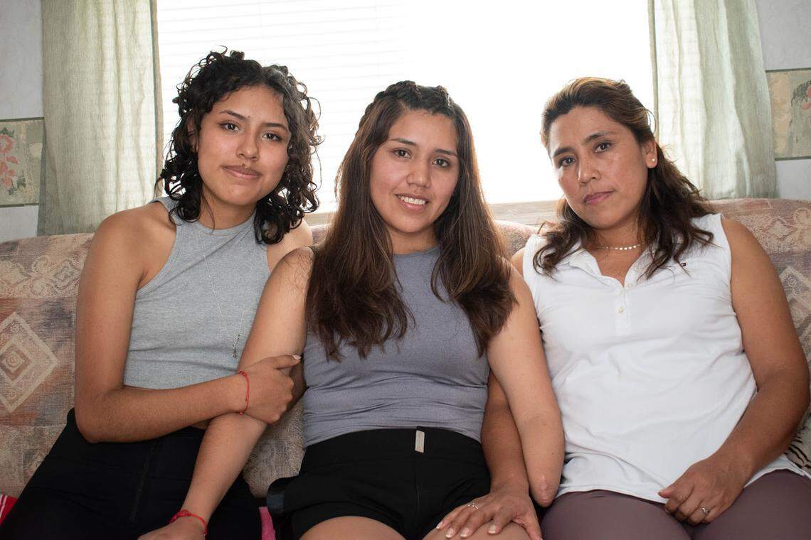 Brigite Valverde, center, with her sister, Wara (left) and mother, Brenda (right) moved from Bolivia to Opa-locka in hopes Brigite can get a functioning prosthetic arm.