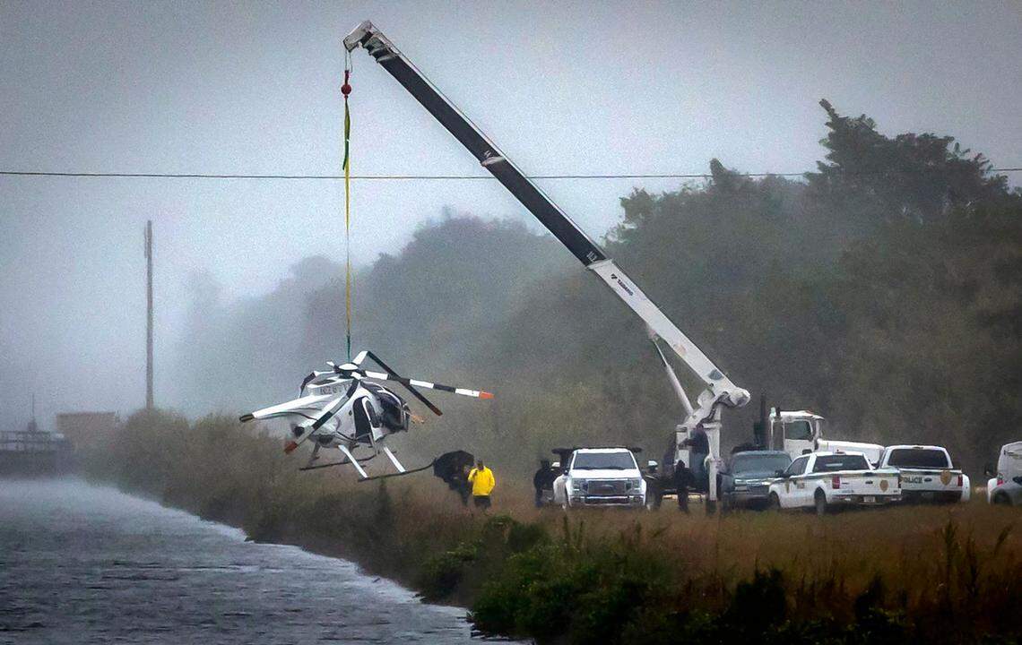 Miami, Florida, December 28, 2023 - A crane hoists out of a canal a helicopter that crashed in Southwest Miami-Dade County on Wednesday, Dec. 27, 2023.