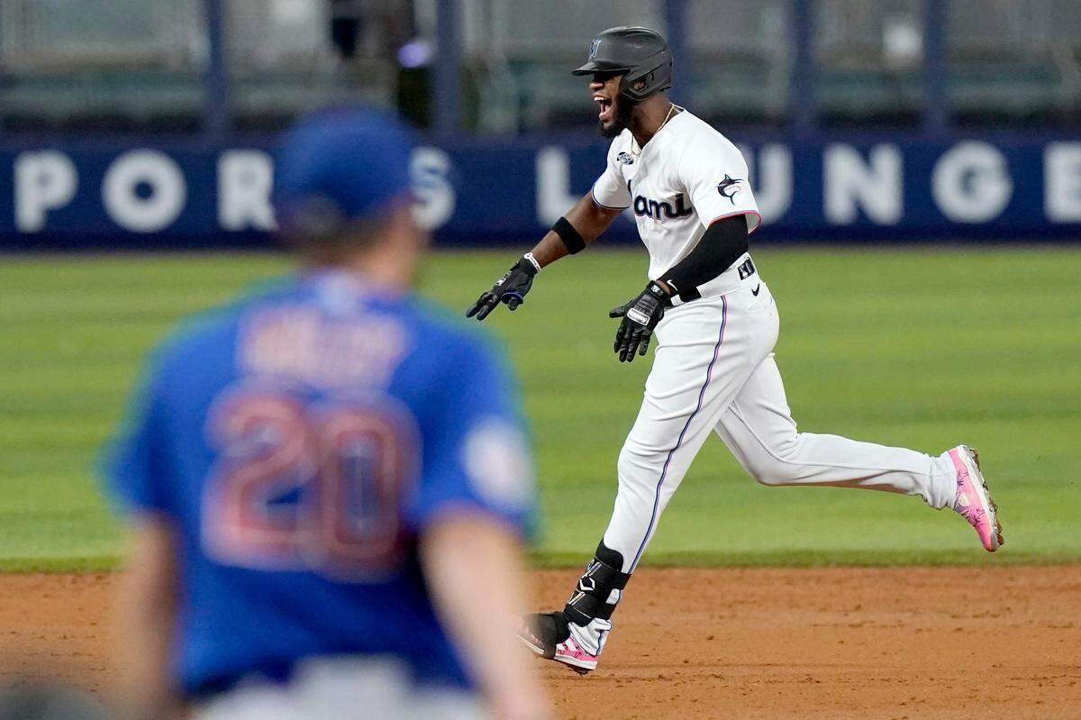 Miami Marlins’ Bryan De La Cruz , right,runs the bases after hitting a grand slam off Chicago Cubs starting pitcher Wade Miley (20) during the third inning of a baseball game Monday, Sept. 19, 2022, in Miami. (AP Photo/Lynne Sladky)
