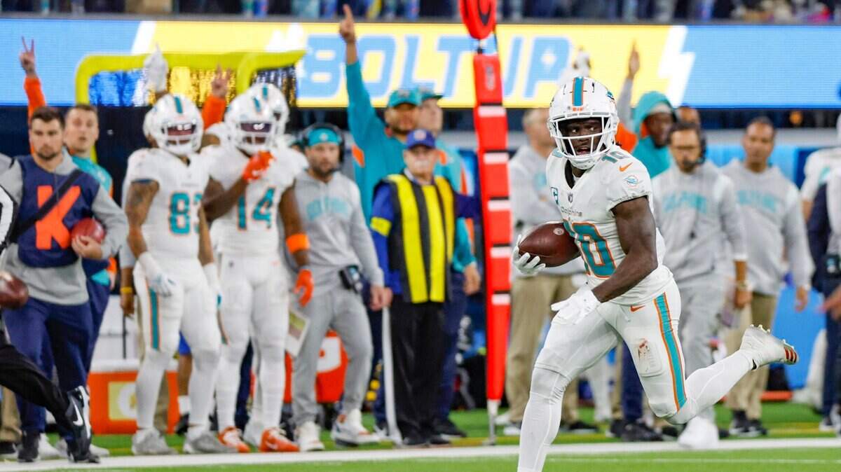 Miami Dolphins wide receiver Tyreek Hill (10) runs to score a touchdown after picking up a fumble by Miami Dolphins running back Jeff Wilson Jr. (23) in the second quarter during the game against the Los Angeles Chargers at SoFi Stadium in Inglewood, California on Sunday, December 11, 2022.