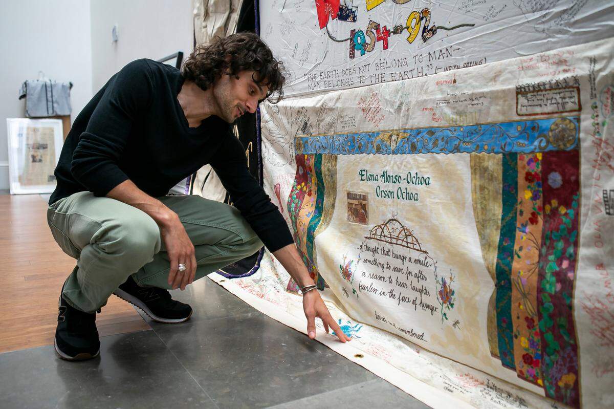 Huston Ochoa, 33, looks at a quilt panel his family made which is part of the AIDS Memorial Quilt that is on display as part of the exhibit, A Matter of Time: Examining Forty Years of AIDS While Living through a Pandemic, at the Coral Gables Museum in Miami, Florida on Monday, April 5, 2021. OchoaÕs family made the quilt panel in honor of his mother and father who both died of AIDS when he was a young boy.