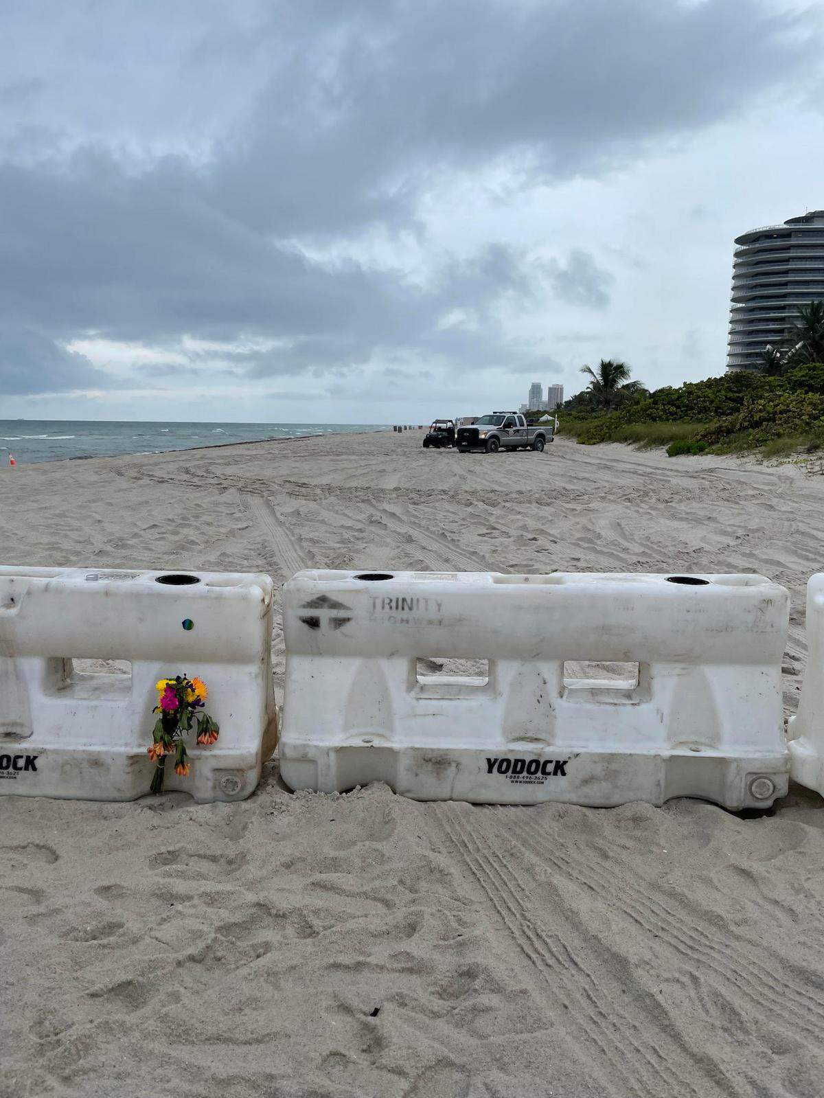 People are leaving flowers at a beachfront barrier in Surfside.