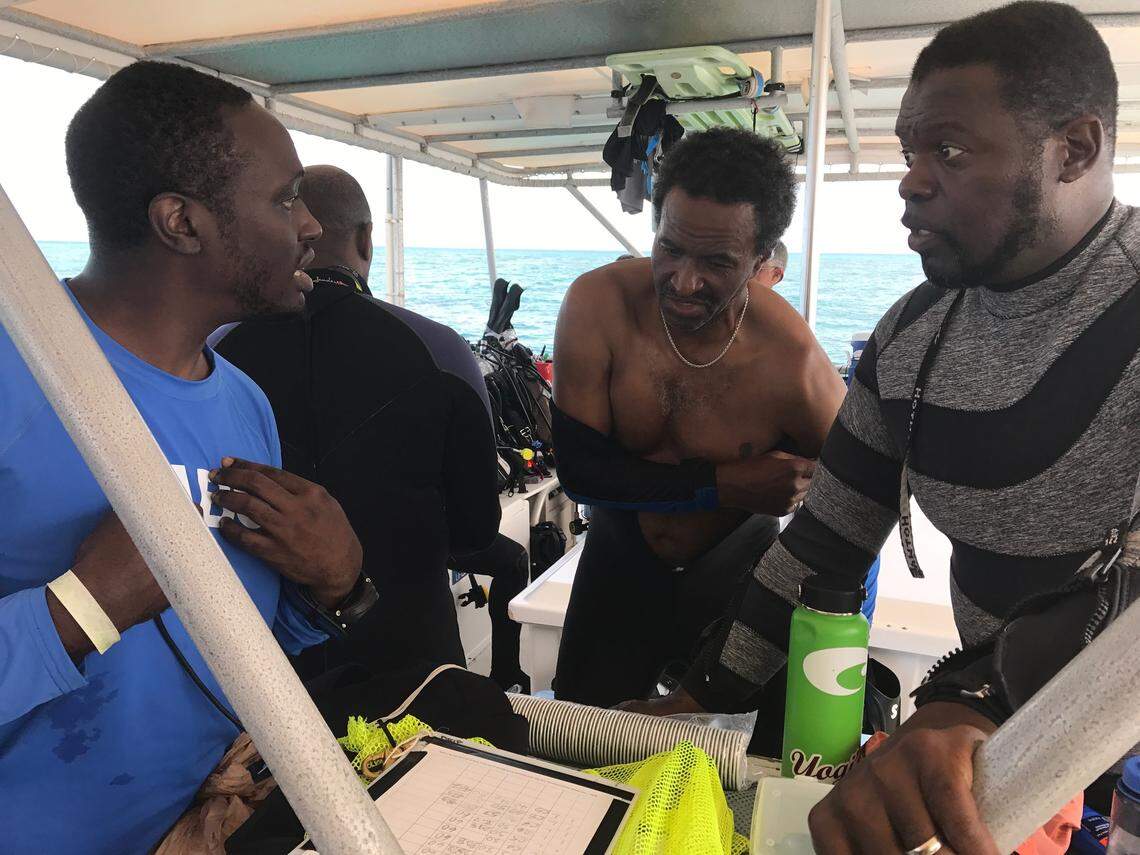 Philip Obgonna, Kamau Sadiki and Kramer Wimberley, discuss details of their dive before descending on what government researchers believe to be recently uncovered portions of the Slobdona ship wreck on Molasses Reef off Key Largo, on Friday, June 9, 2018.