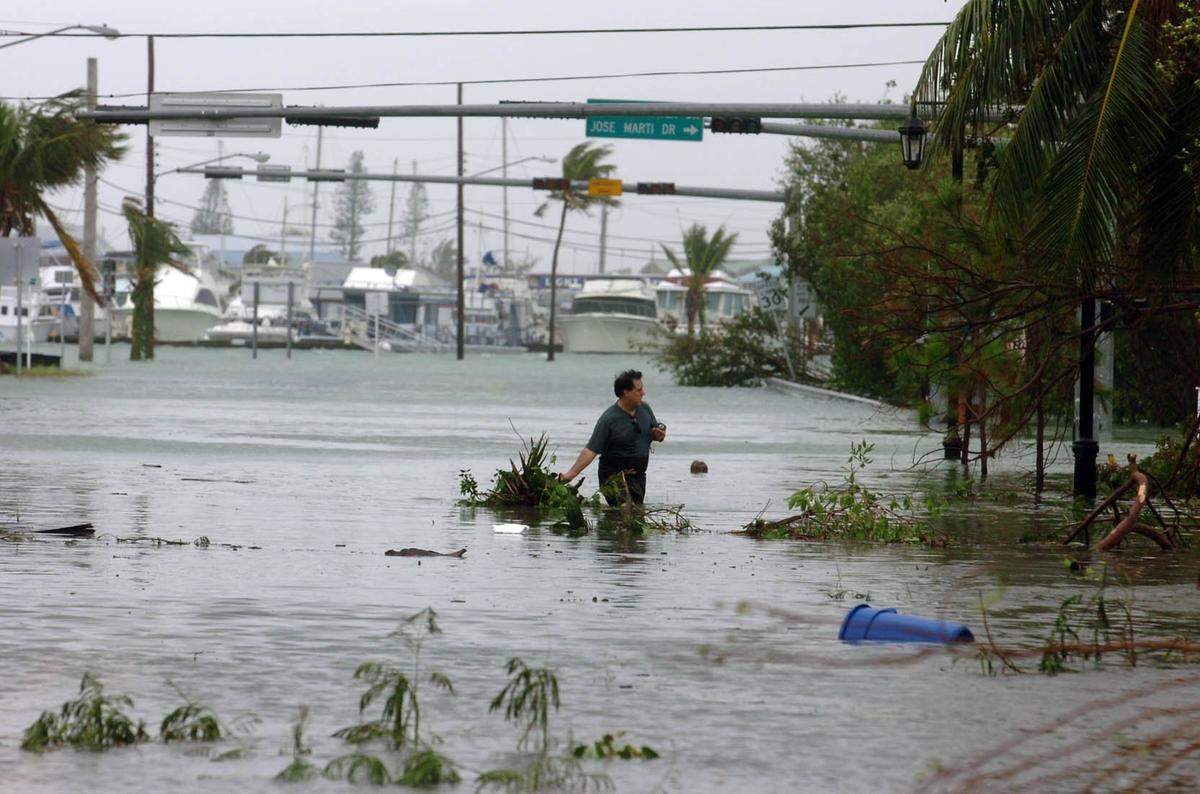 A man clears floating debris from a flooded U.S. 1 in Key West where high water blocked the island after hurricane Wilma’s high winds caused a storm surge.
