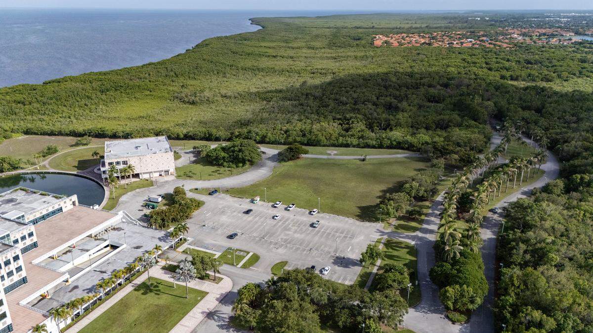 A drone’s-eye view shows the Palmetto Bay Village Center office campus, at bottom, on a flood-hazard site on Biscayne Bay on July 2, 2025. A nature preserve abuts the site to the south. Ahe top is the Saga Bay residential development. Both Saga Bay and the office campus, built as Burger King’s corporate headquarters in the 1980s, were heavily damaged by storm surge and winds from Hurricane Andrew in 1992.