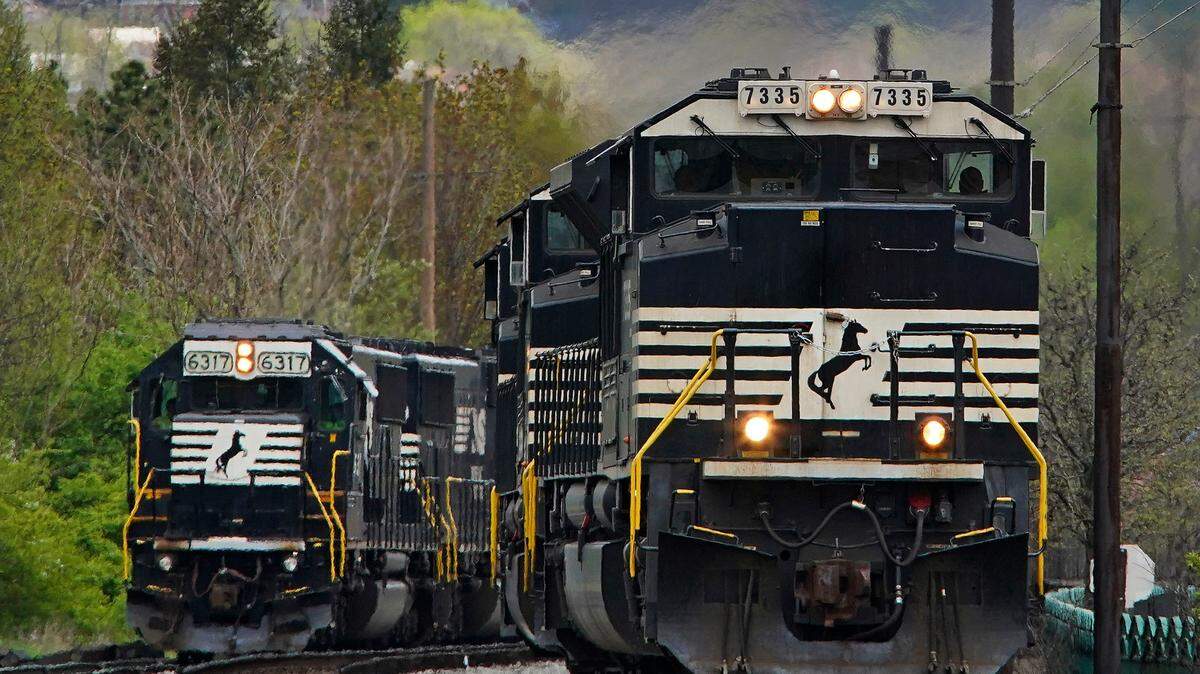 FILE - A Norfolk Southern freight train passes a train on a siding as it approaches a crossing in Homestead, Pa., Wednesday, April 27, 2022. Freight railroads and their unions are facing increasing pressure from business groups and the White House to settle their contract dispute. They face a looming strike deadline on Friday, Dec. 9. (AP Photo/Gene J. Puskar, File)