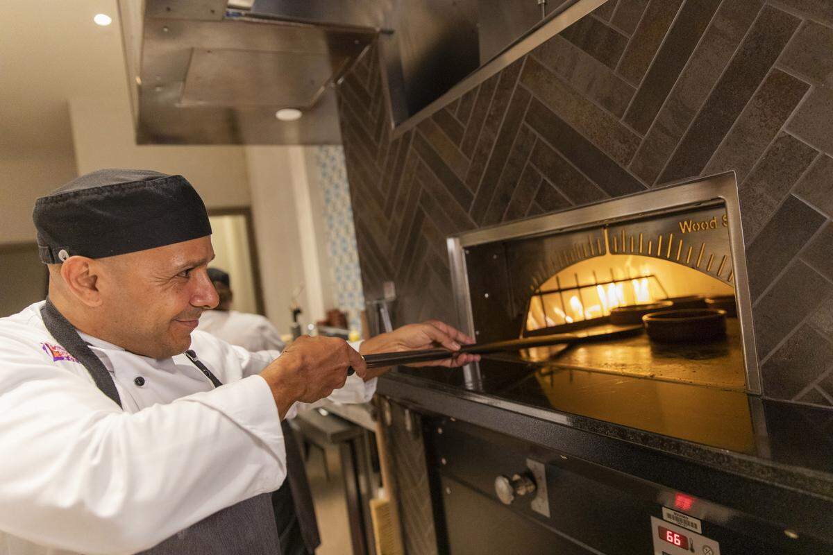 A chef prepares dishes in the onstage tapas kitchen in Tolédo, a Spanish-themed restaurant in Gran Destino tower at Disney’s Coronado Springs Resort.