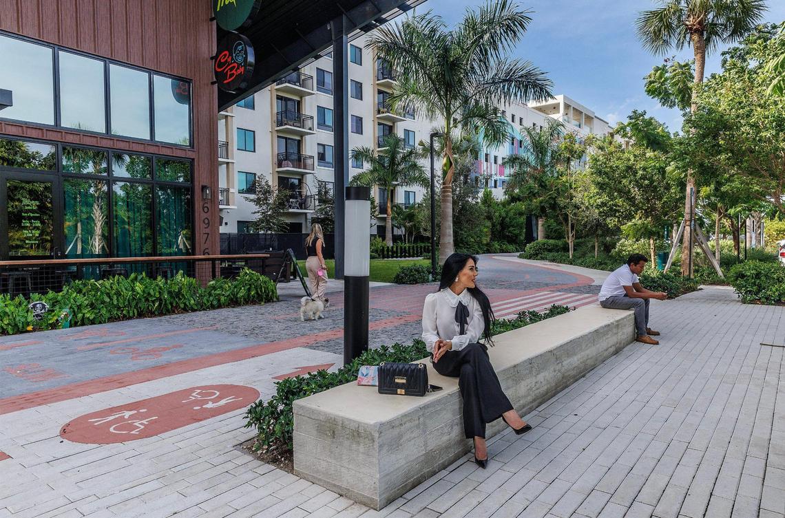 Lilibet Capote waits for a friend on a bench on the first quarter-mile stretch of the Ludlam Trail that passes in front of the new Thorn cocktail bar and restaurant and Windsor apartments just off Bird Road in west Miami-Dade.