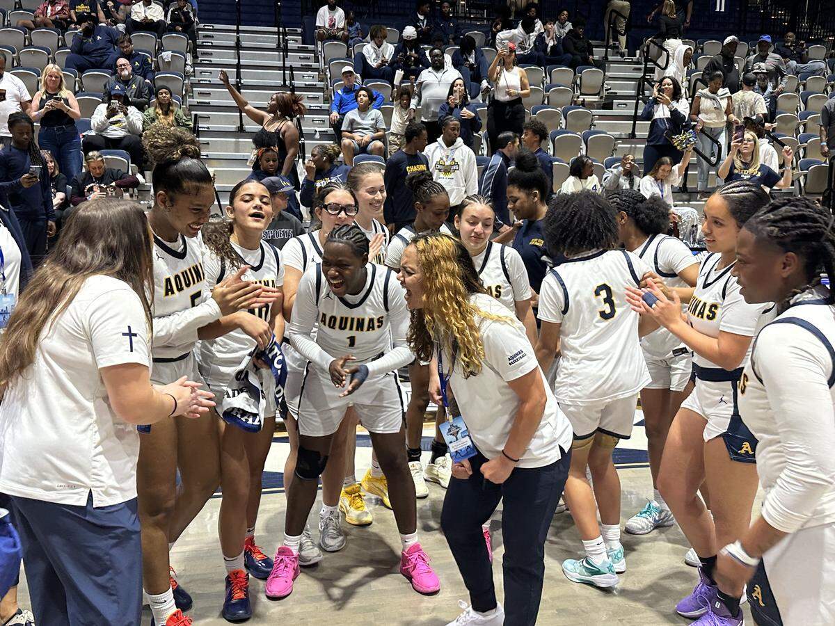 St. Thomas Aquinas coach Emily Williams (middle) is fired up with her players after they won the Class 6A state championship on Saturday against Palm Bay Bayside at UNF Arena in Jacksonville, Fla.