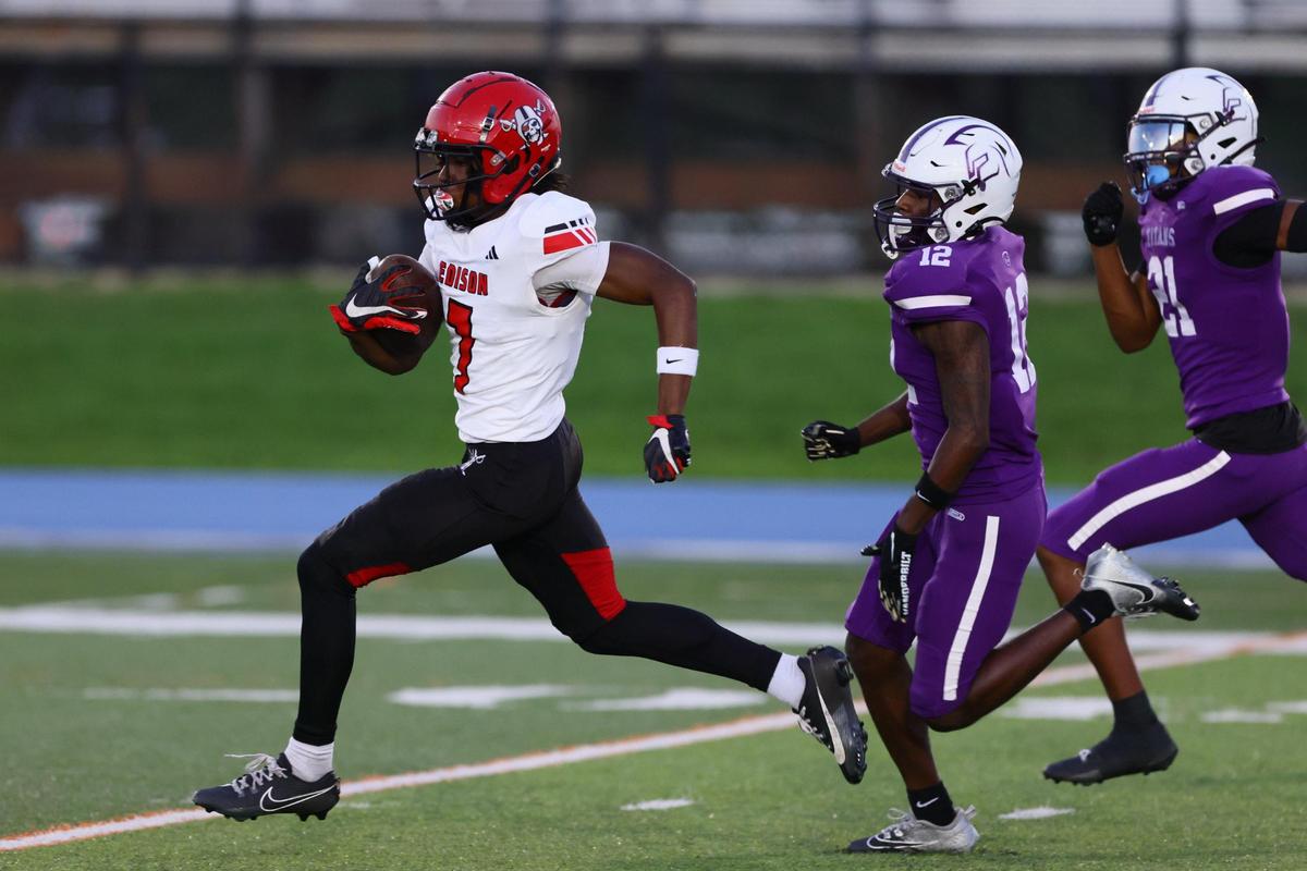 Edison Red Raiders wide receiver Jaylen Moore (7) runs with the football past True North Titans outside linebacker Mark Coats (12) during the first quarter of a high school football Class 1A Region 4 playoff game at Tropical Park in Miami, Florida, on Thursday, November 21, 2024.