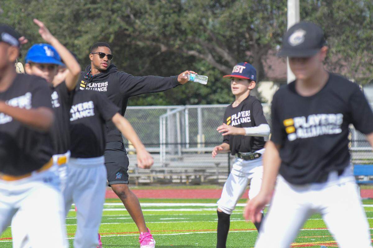 Miami Marlins utility player Xavier Edwards directs campers through stretches and warmups during his sixth-annual baseball skills camp on Saturday, Dec. 23, 2023, at North Broward Preparatory School in Coconut Creek, Florida.