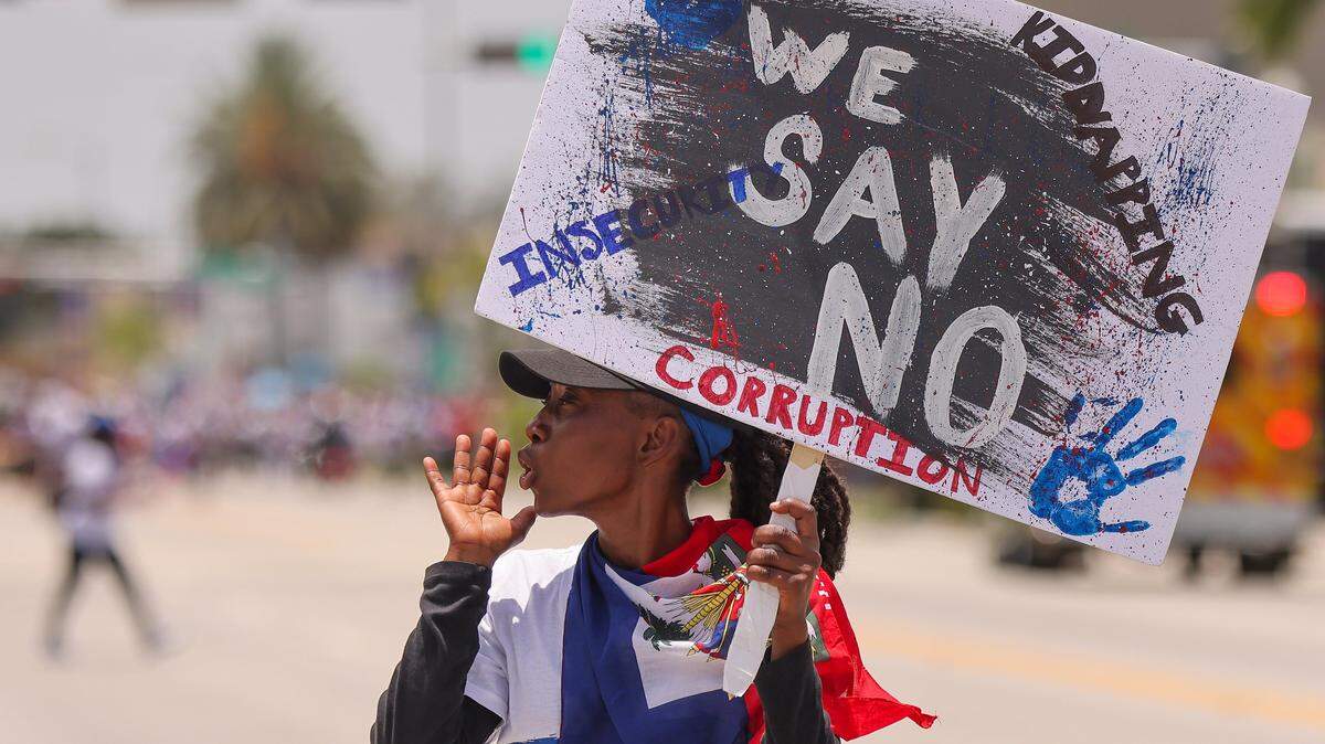 A marcher walks ahead of of the large crowd of about 3,500 North Miami residents, and members of the South Florida Haitian community as they joined Haitians across the United States and the world while marching towards City Hall from North Miami High School on Sunday, July 9, 2023 to demand “Relief for Haiti.”  
