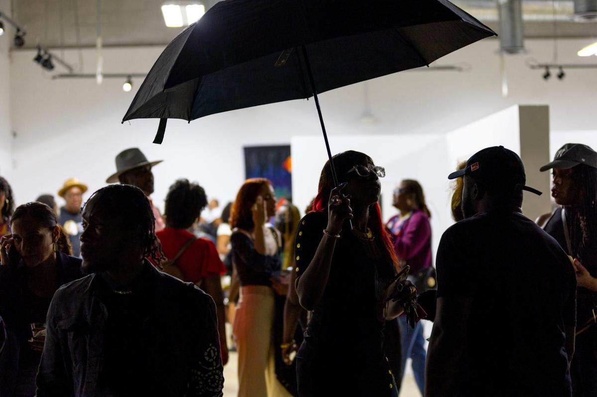 People socialize during the Preview for The Art of Transformation event at The ARC and Logan Building in Opa-locka, Florida, on Wednesday, November 30, 2022. The event is a five-day, three-block Mecca of African and Haitian art fair coinciding with Art Basel Miami Beach 2022 and just one of over 40 ‘exhibits’ part of 2022 Art of Black Miami.