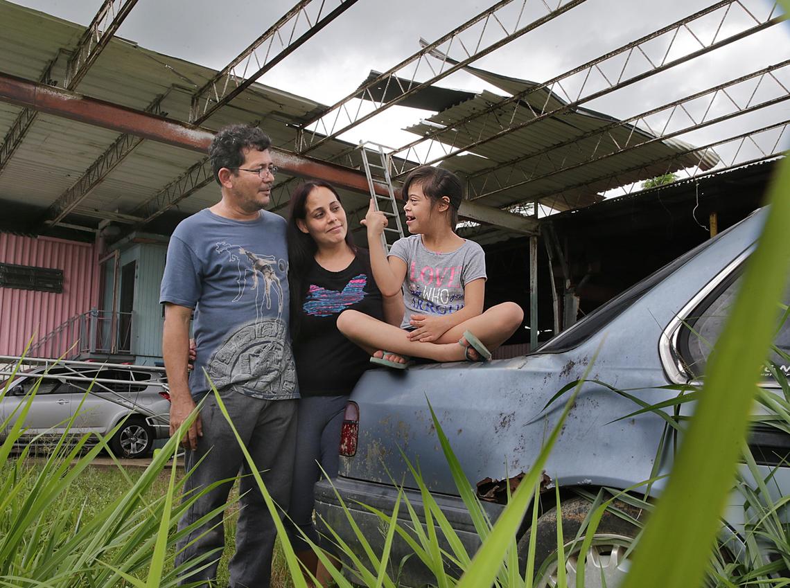 Yesenia Santiago and her husband, Roberto Colón, with their daughter Marylee, 10, outside the family’s home in Añasco, Puerto Rico. Marylee has Down syndrome, and it has been difficult for the family to make sure she gets the services she needs after Hurricane Maria.