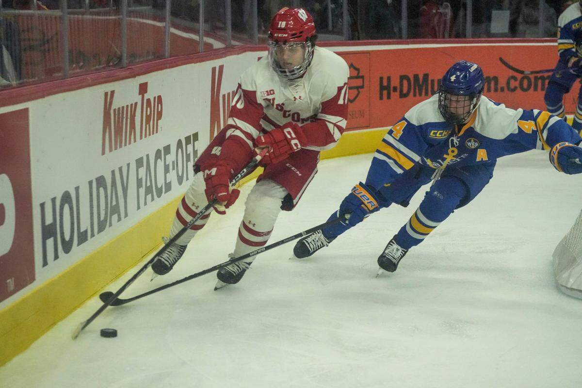 Wisconsin forward Owen Lindmark (18) and Lake Superior State defenseman Jacob Bengtsson (4) compete during the Kwik Trip Face-Off Tournament Wednesday, Dec. 28, 2022, at Fiserv Forum in Milwaukee. Mjs 12282022 Uwhockey28 Ec019810 1