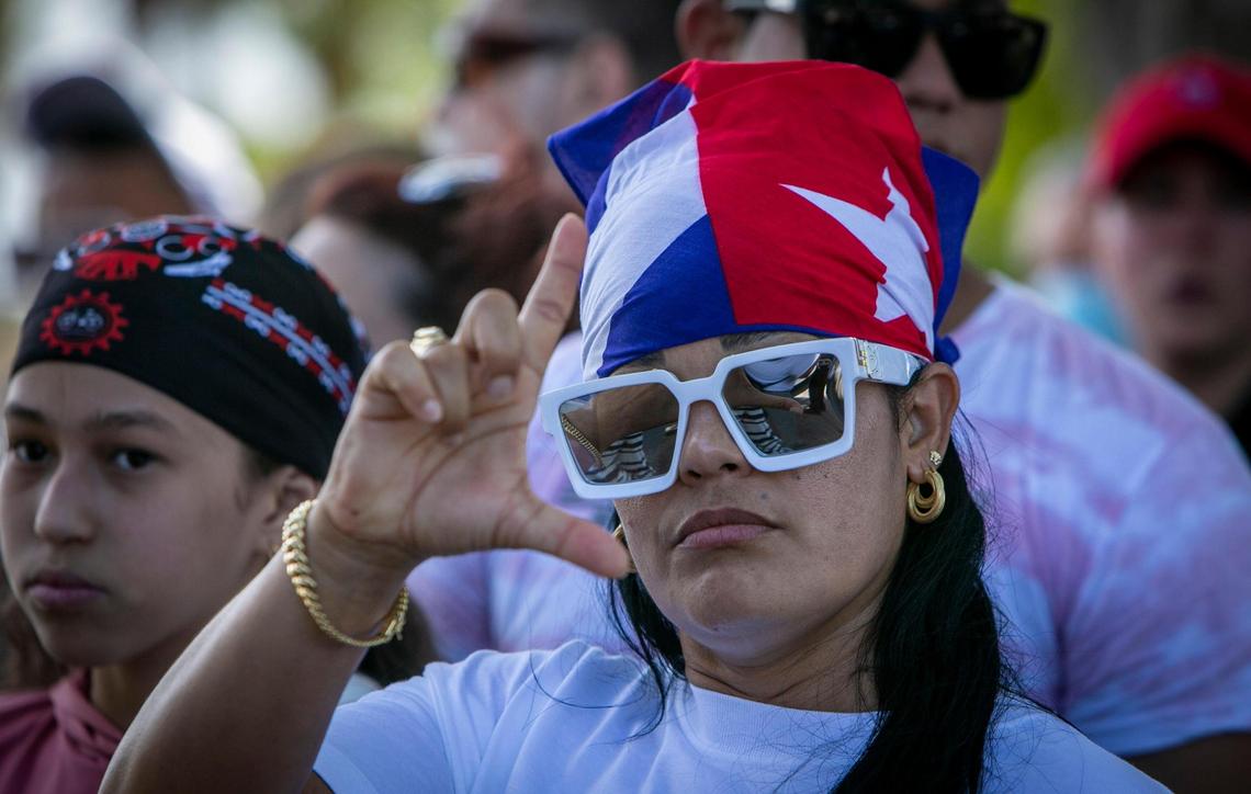 Joanna Quesada gives the Liberty sign as she waits to board a Washington, D.C.-bound bus at Grapeland Park in Miami on Friday, July 16, 2021. Cubans boarded buses for a trip to Washington to protest in support of Cubans currently demonstrating in the island.