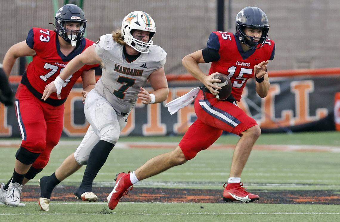 Columbus Explorers quarterback Alberto Mendoza (15) scrambles with the ball as Mandarin Mustangs Jackson Copeland (7) gives chase in the second half of the game of the FHSAA State Championships, Class 4M, at Bragg Memorial Stadium in Tallahassee, Florida, on Friday, December 8, 2023. 