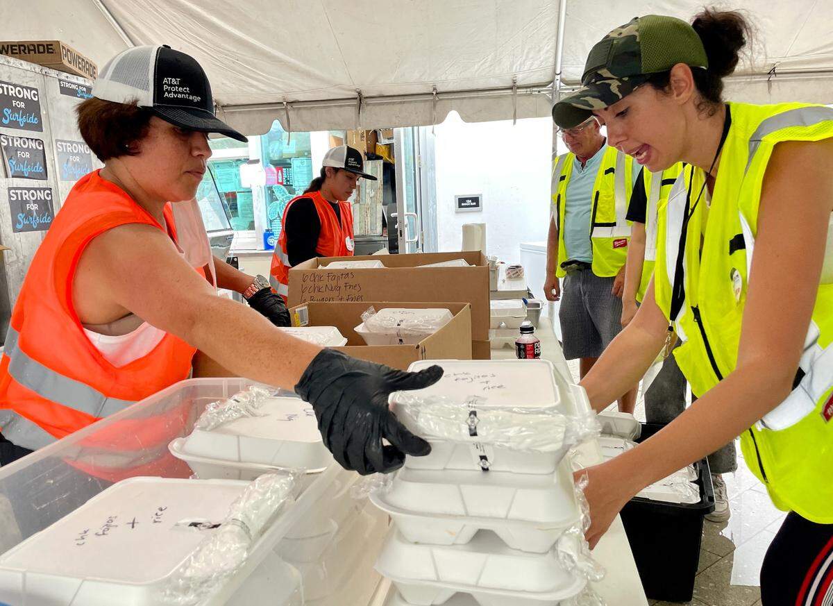 Gloria Segura, left, and Leat Ruben Unger pack kosher meals for delivery at the Surfside Community Center.