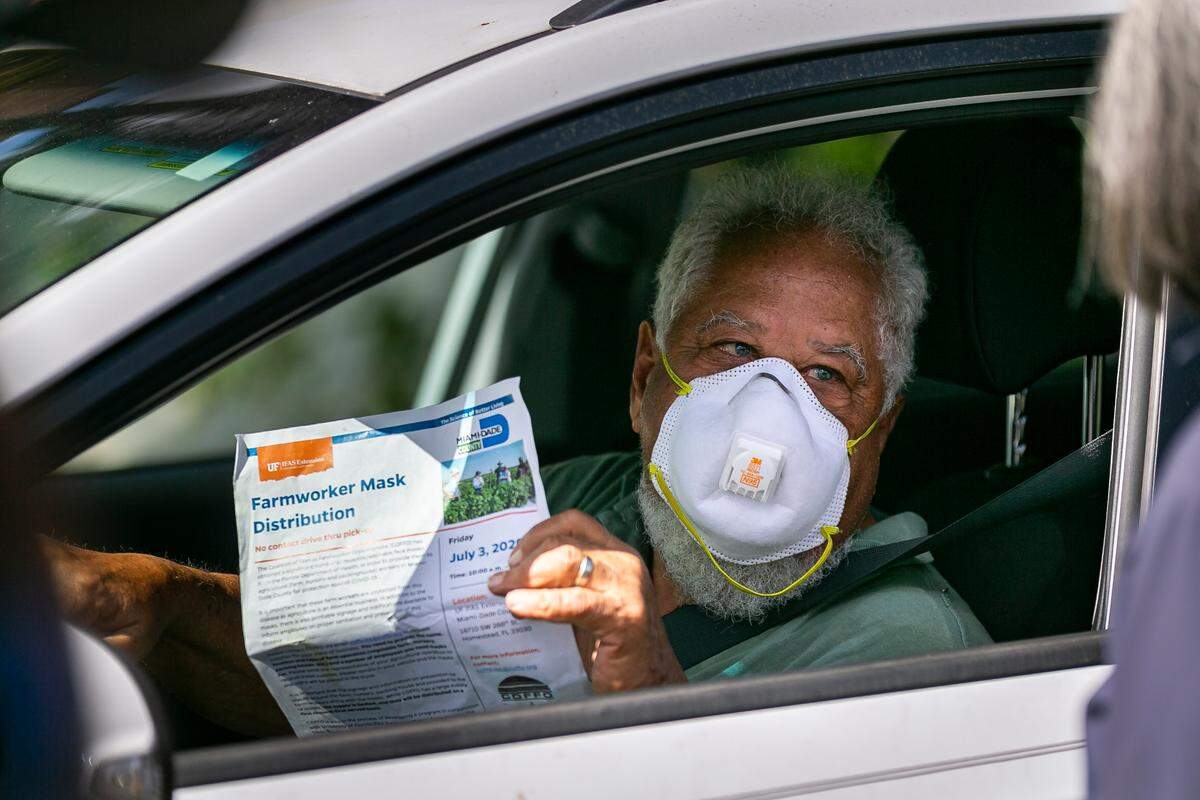 Tony Delfosse, 77, from Delfosse Nursery, waits to receive a bag with reusable and washable face masks alongside COVID-19 informational packets from the Coalition of Florida Farmworker Organizations at the UF IFAS Extension office in Homestead, Florida, on Friday, July 3, 2020.