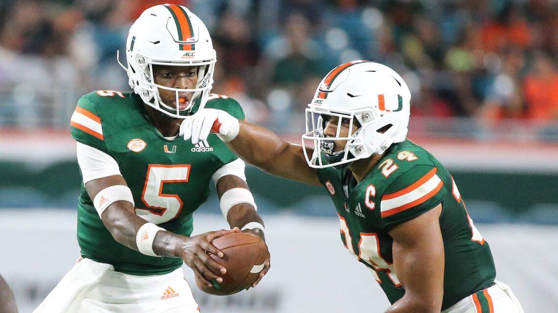 Miami Hurricanes quarterback N’Kosi Perry (5) hands the ball to running back Travis Homer (24) in UM’s home-opening win against Savannah State Saturday night at Hard Rock Stadium in Miami Gardens.