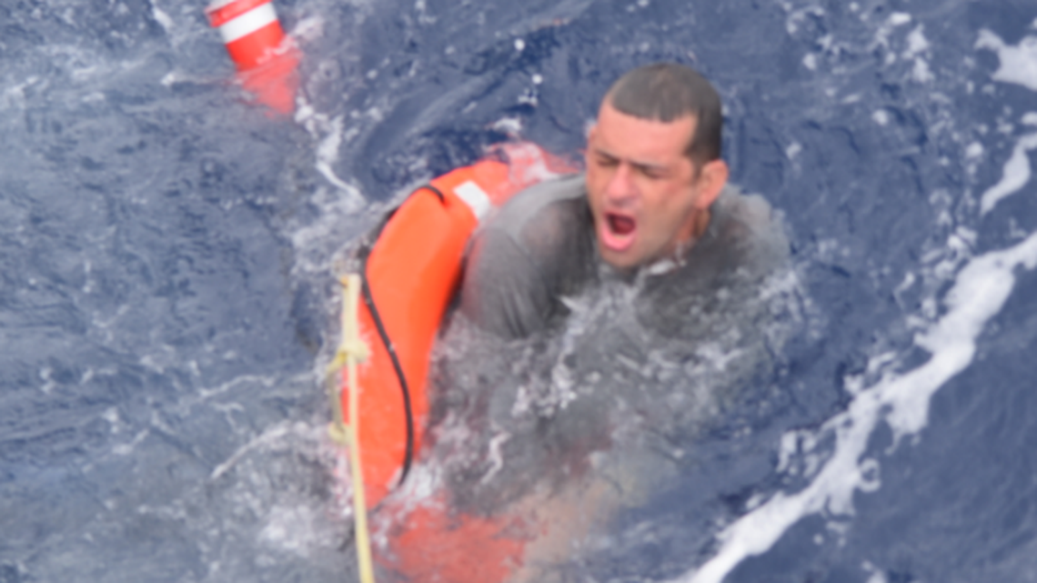 A man clinging to a life preserver is pulled to safety from the ocean off Key West Tuesday afternoon, July 6, 2021. He is among 13 people rescued by the U.S. Coast Guard and a merchant vessel crew.