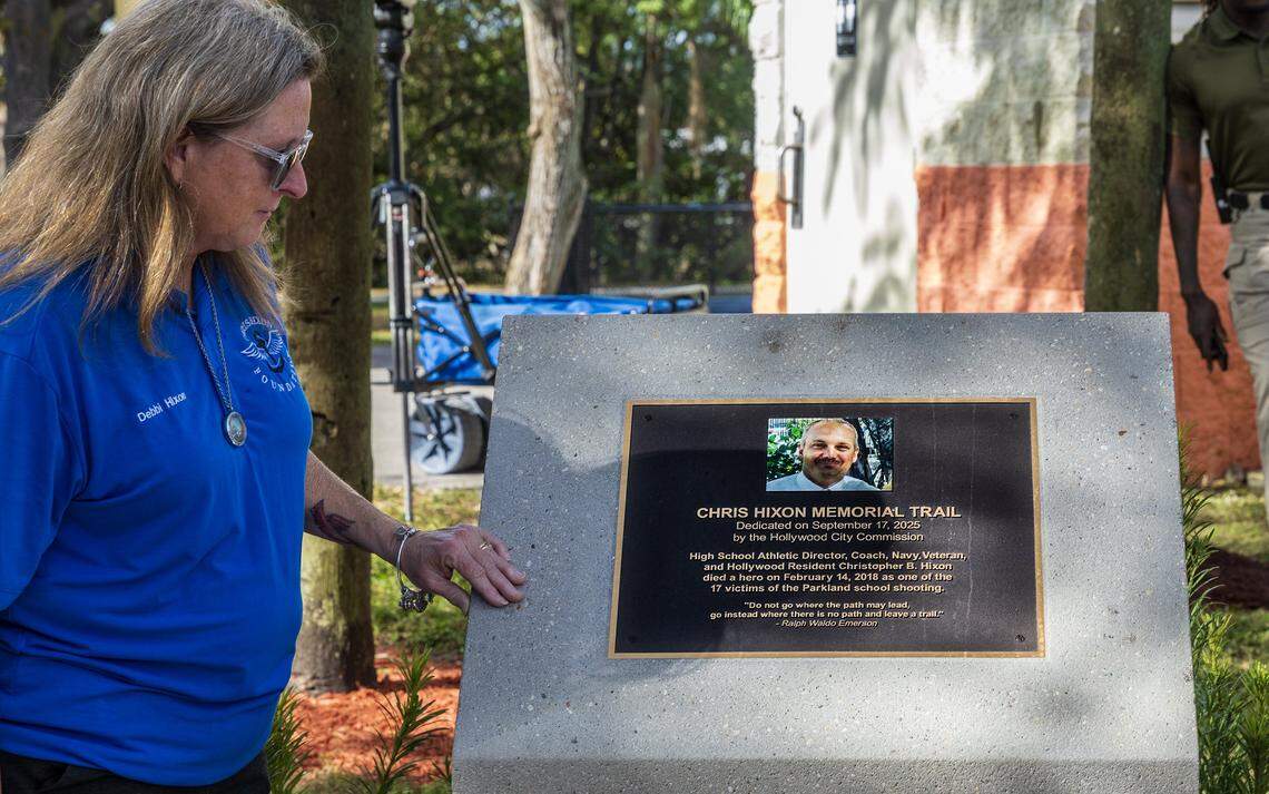 Debra Hixon looks at the plaque honoring her husband at the Chris Hixon Memorial Trail at Stan Goldman Memorial Park in Hollywood.