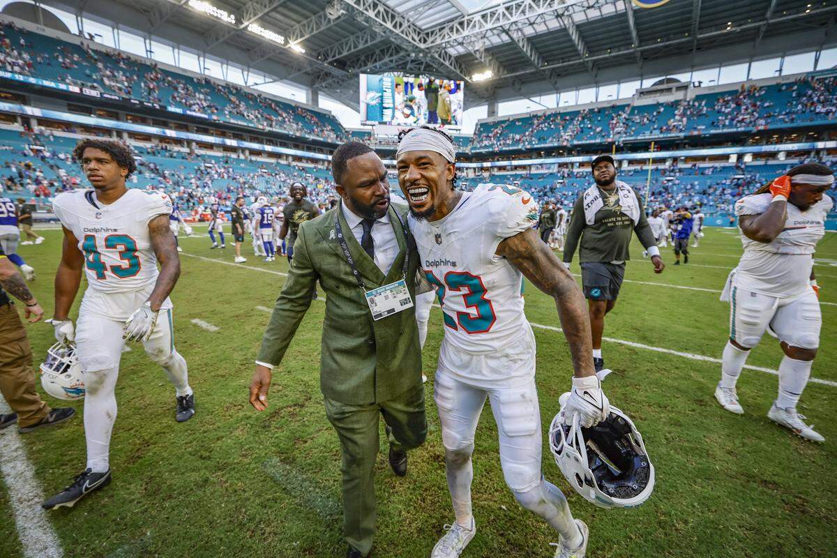 Miami Dolphins General Manager Anthony "Champ" Kelly greets cornerback Jack Jones (23) at midfield after the Dolphiins defeat the Buffalo Bills during the NFL football game at Hard Rock Stadium in Miami Gardens, Florida on Sunday, November 9, 2025.