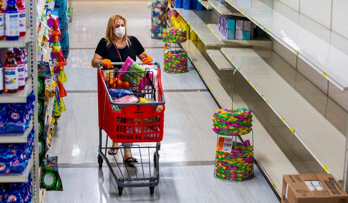Surabe Perez strolls down the paper and cleaning supplies aisle before being restocked at a Sedano’s Supermarket in Hialeah, Florida on Wednesday, April 1, 2020.