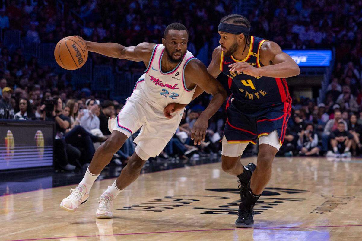 Miami Heat forward Andrew Wiggins (22) drives past Golden State Warriors guard Moses Moody (4) during the second half of an NBA game at Kaseya Center on Tuesday, March 25, 2025, in Miami, Florida.