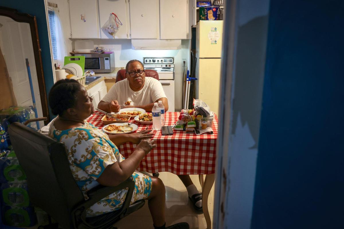 Carol Hatchet, 61, and Freddie Gatlin, 74, enjoy an early dinner inside their mobile home.