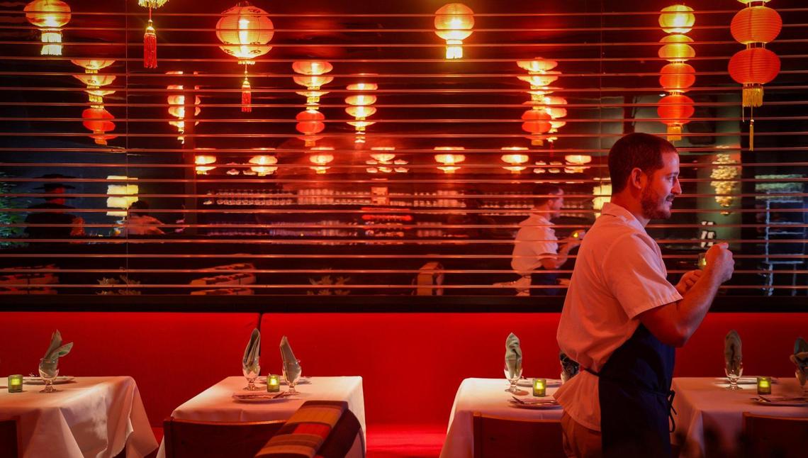 Chef Adrian Ochoa passes the long mirrored wall at Double Luck Chinese restaurant.