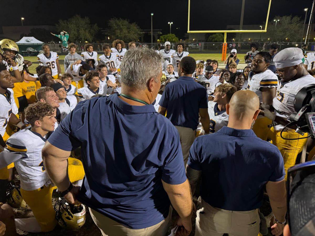St. Thomas Aquinas’ players and coaches meet after the Raiders’ 49-42 double overtime win over Delray Beach Atlantic on Friday night in the Region 4-5A final.