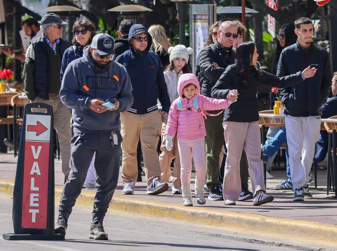 Tourists walk on Ocean Drive as a cold snap descends on S. Florida during their visit to Miami Beach’s Art Deco District.Temperatures in South Florida dipped overnight as the polar vortex brought an Arctic blast and cold air. With a high of 56 degrees, residents and visitors swapped shorts, bikinis, and activewear for hoodies, sweaters, and jackets on Sunday, February 1, 2026, in Miami Beach, Florida.