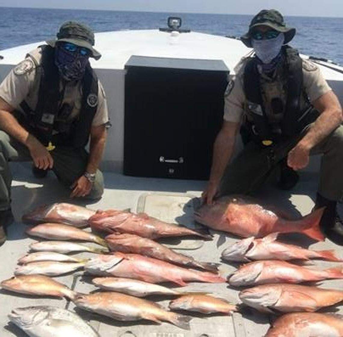 Florida Fish and Wildlife Conservation Commission officers pose April 10, 2020, with an illegal catch they say was made by a group fishing in a no take zone in the waters of the Dry Tortugas off Key West.