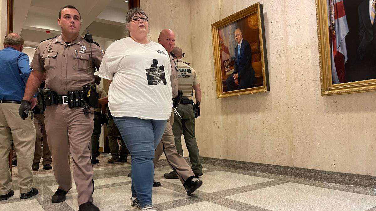 Un manifestante no identificado fue arrestado y escoltado fuera de oficina del gobernador Ron DeSantis en el Capitolio de Florida el 3 de mayo de 2023.
