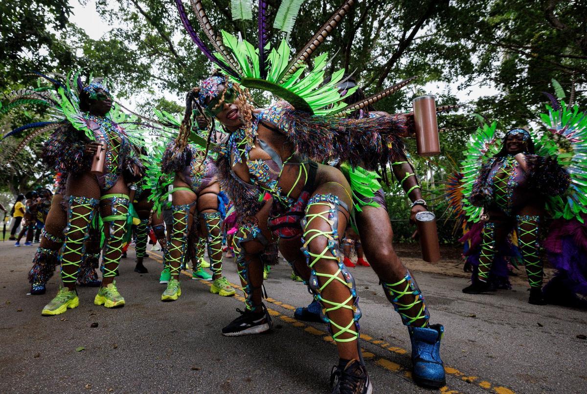 Two masqueraders from BFE MAS band dance togetehr during the Parade of Bands at Miami Carnival on Sunday, Oct. 13, 2024, at Miami-Dade County Fair Expo.