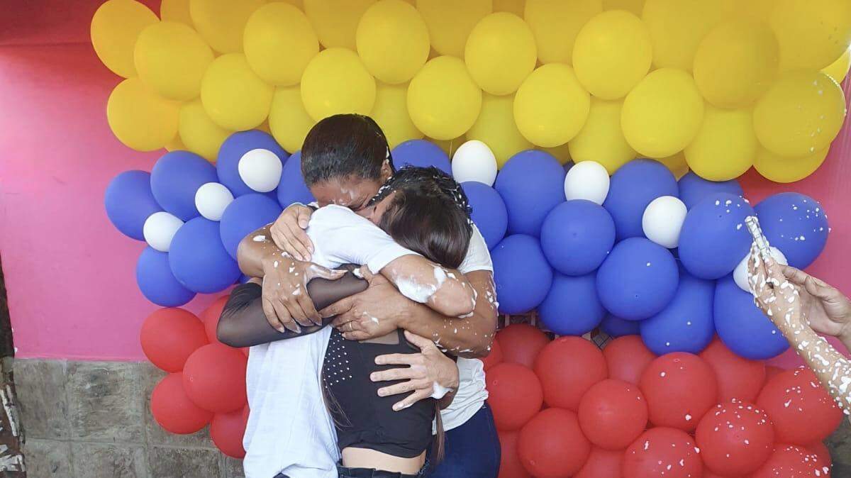 El migrante venezolano Jonferson Valera Yamarte abraza a su familia al llegar a su hogar en Maracaibo, Venezuela. Foto cortesía de la familia Yamarte.