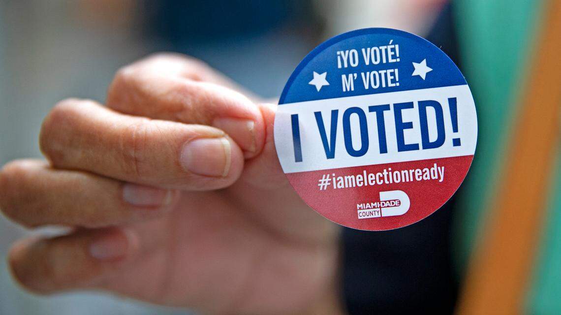 Miami-Dede resident Zaida Perez shows her sticker after casting her vote on first day of early voting for the general election at Shenandoah Branch Library located at 2111 SW 19th St. on Monday, October 19, 2020, in Miami, Florida.